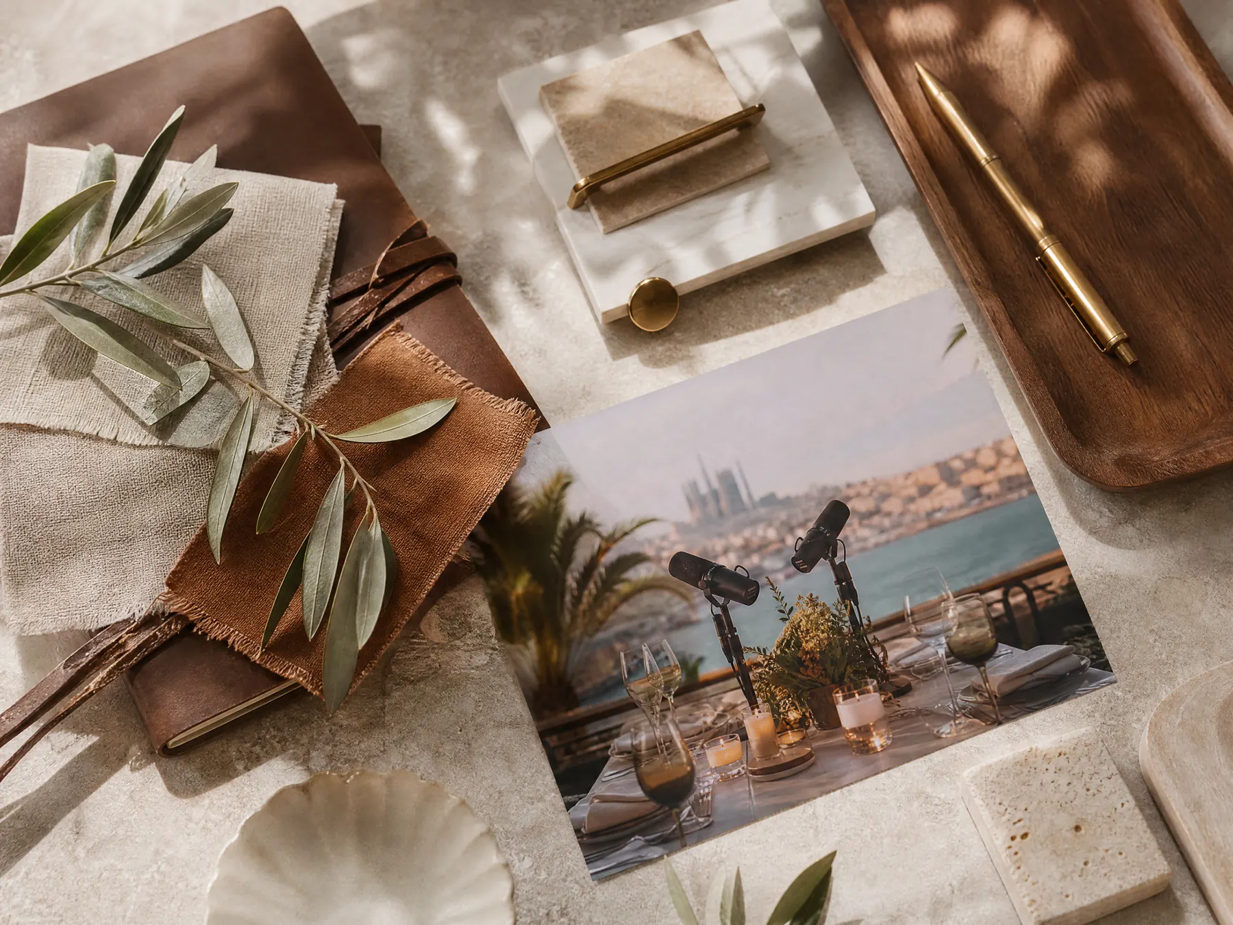 Conceptual editorial of a wedding planner desk with linen swatches and a photo of the podcast setup.